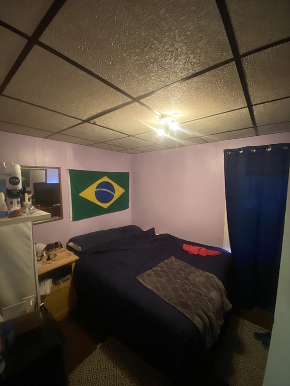 23 Suffolk Street Worcester, MA 01604 - Photo 13 of 18 a bedroom with a bed and a dresser
