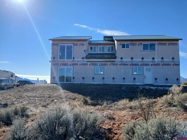 a view of a house with a wooden fence