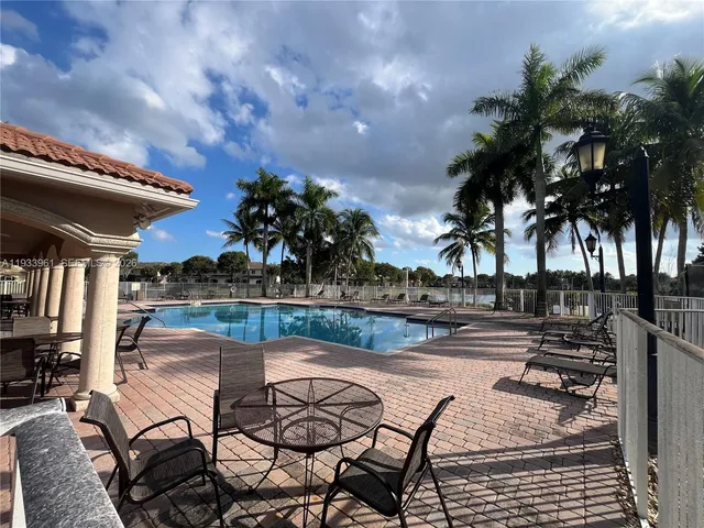 a view of a swimming pool with a patio and wooden floor