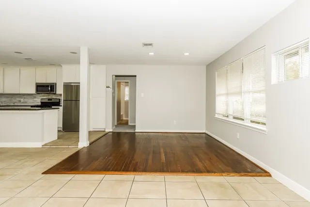 a view of a kitchen with kitchen island granite countertop stainless steel appliances cabinets and a counter top space