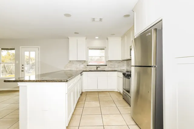 a large kitchen with a refrigerator a sink and dishwasher