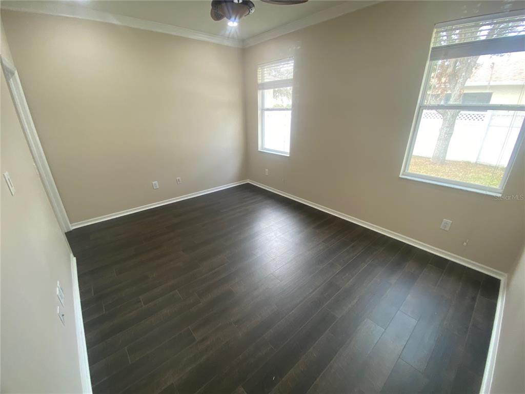 2409 Spring Hollow Loop Wesley Chapel, FL 33544 - Photo 19 of 47 an empty room with wooden floor and windows