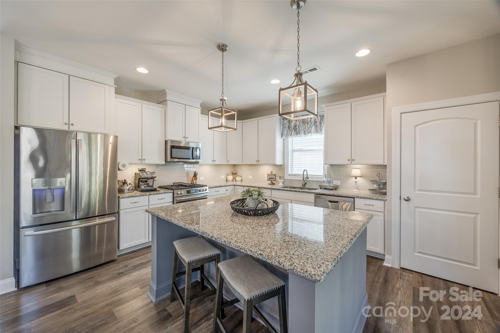 133 Pine Eagle Drive Rock Hill, SC 29732 - Photo 6 of 25 a kitchen with granite countertop stainless steel appliances a refrigerator a stove a sink a center island and chairs