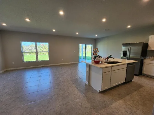a view of kitchen with refrigerator and microwave