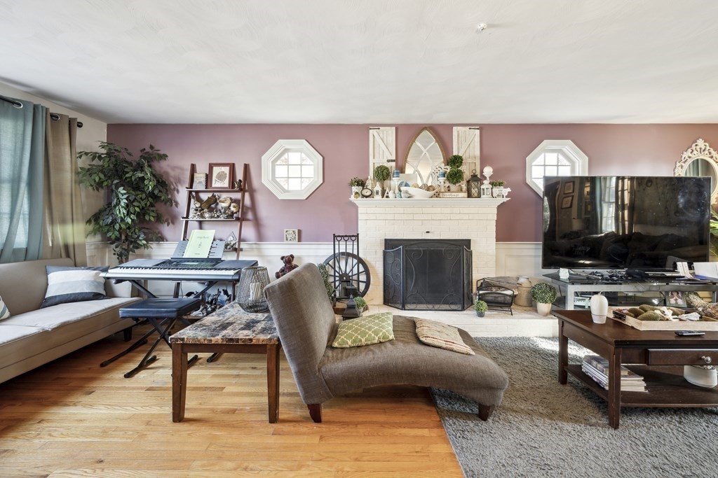 8 Robert Plunkett Circle Randolph, MA 02368 - Photo 15 of 22 a living room with furniture a flat screen tv and a fireplace