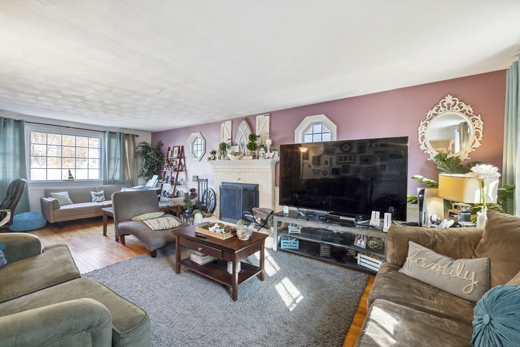 8 Robert Plunkett Circle Randolph, MA 02368 - Photo 5 of 22 a living room with furniture a flat screen tv and a fireplace