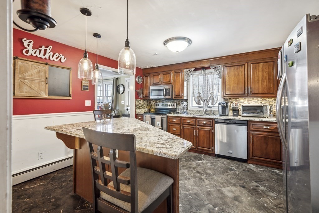 8 Robert Plunkett Circle Randolph, MA 02368 - Photo 8 of 22 a kitchen with stainless steel appliances granite countertop a stove a sink dishwasher and a refrigerator with wooden floor