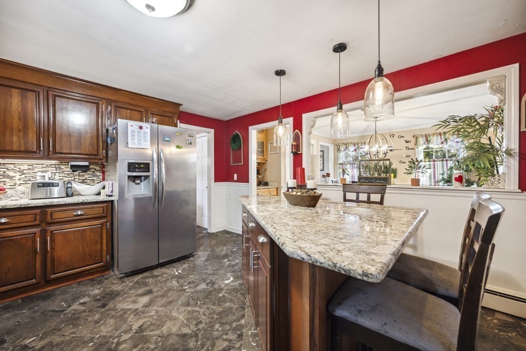 8 Robert Plunkett Circle Randolph, MA 02368 - Photo 9 of 22 a kitchen with stainless steel appliances granite countertop a table chairs and a refrigerator