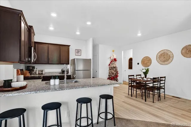 a kitchen with granite countertop a table chairs microwave and cabinets