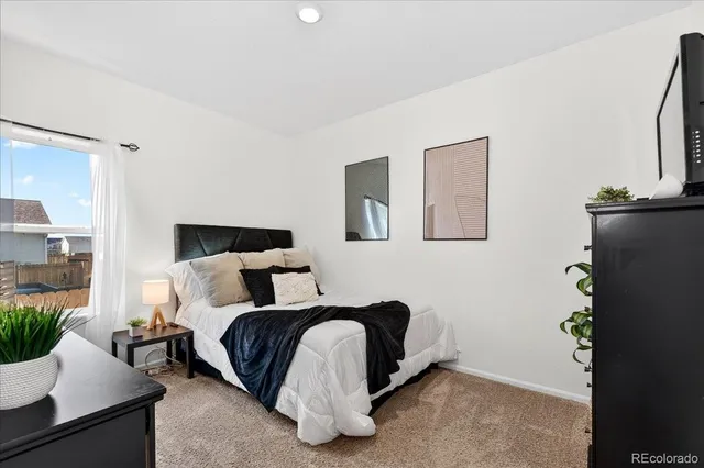 a bedroom with a bed and a potted plant