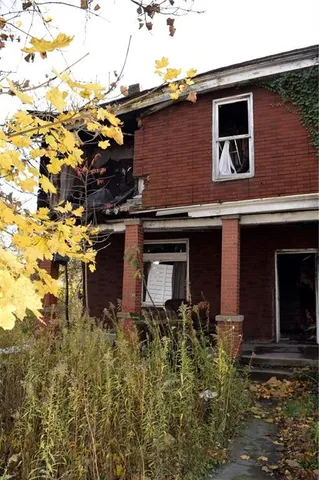 a yellow building with trees in front of it