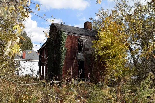 a view of a house with a tree and wooden fence