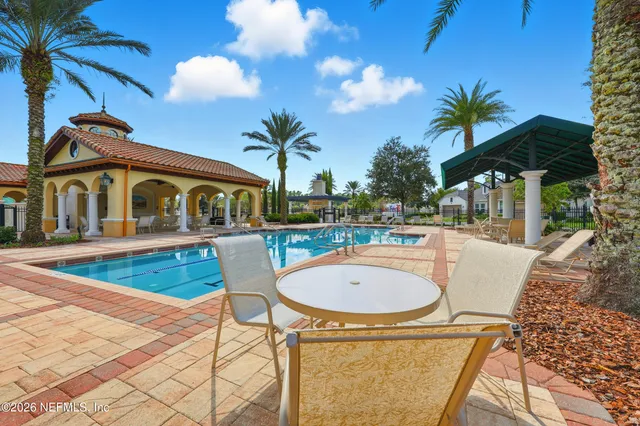 a swimming pool with outdoor seating and barbeque oven