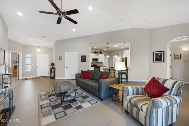 a living room with furniture a flat screen tv and a large window