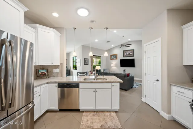 a kitchen with stainless steel appliances kitchen island granite countertop a kitchen island hardwood floor sink and stove