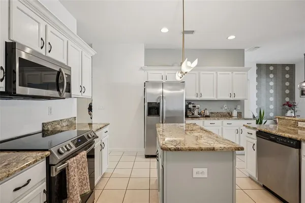 a kitchen with stainless steel appliances granite countertop a sink stove a refrigerator and microwave