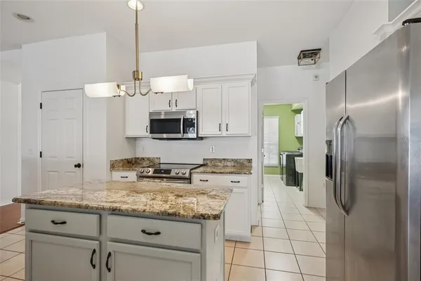 a kitchen with stainless steel appliances granite countertop a sink a refrigerator and a granite counter tops