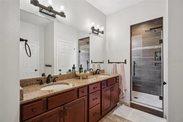 a bathroom with a granite countertop sink shower and a mirror