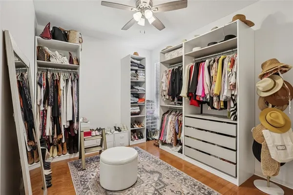 a view of walk in closet with clothes and shoes