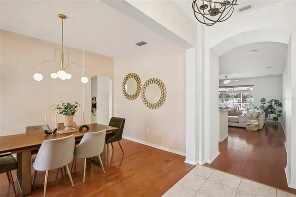 a view of a dining room and livingroom with furniture wooden floor a chandelier