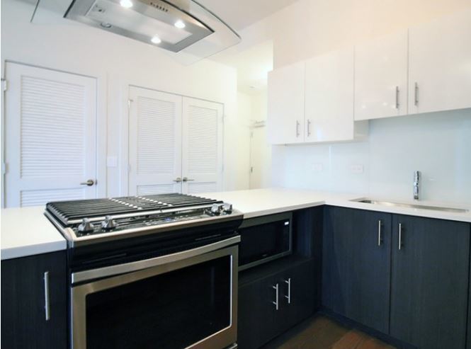 1418 West Addison Street, Unit 201 Chicago, IL 60613 - Photo 5 of 6 a kitchen with wooden cabinets and a stove top oven