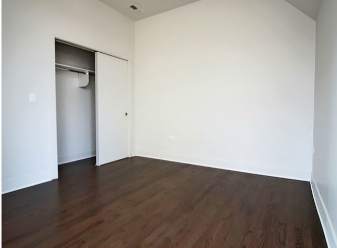 1418 West Addison Street, Unit 201 Chicago, IL 60613 - Photo 6 of 6 an empty room with wooden floor and closet
