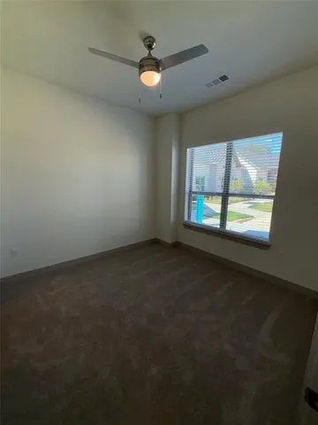 a view of an empty room with a ceiling fan