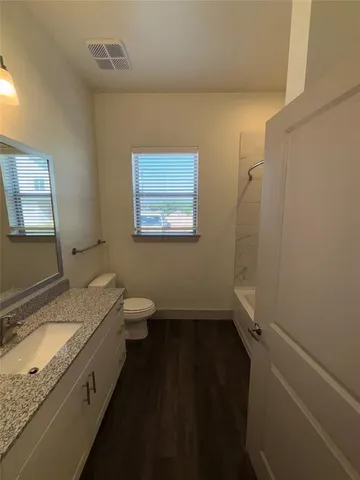 a bathroom with a granite countertop sink and shower