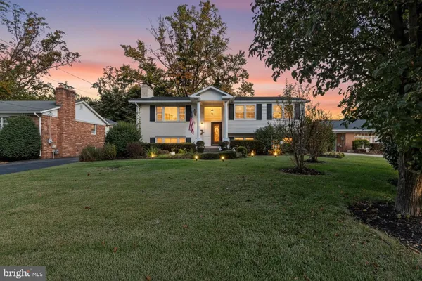 a front view of a house with a yard and trees