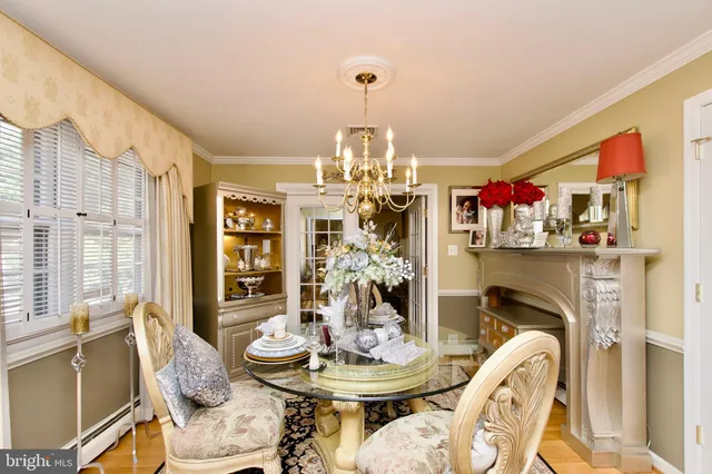 a view of a dining room with furniture a chandelier and wooden floor
