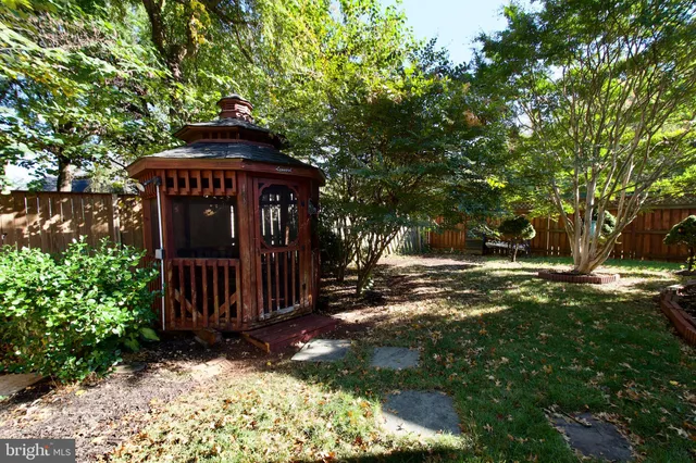 a view of a house with a small yard plants and large tree