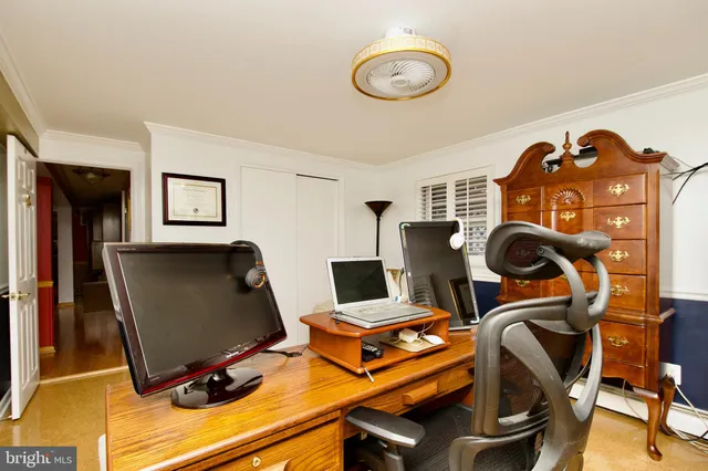 a view of a workspace with furniture and a window