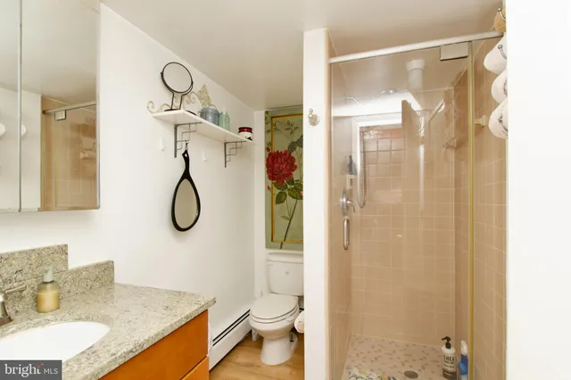 a bathroom with a granite countertop sink toilet and shower