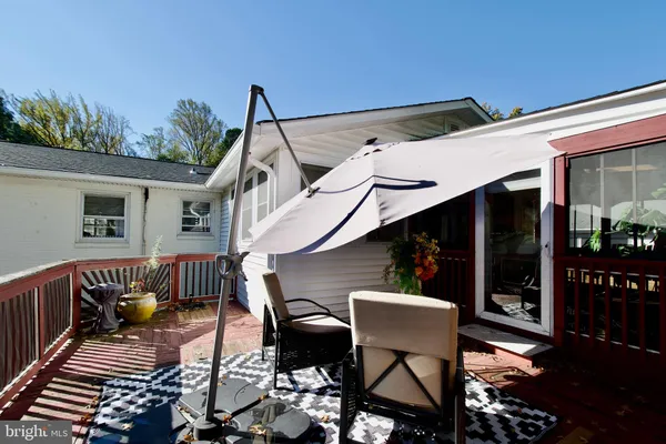 a view of a patio with table and chairs with wooden floor and fence