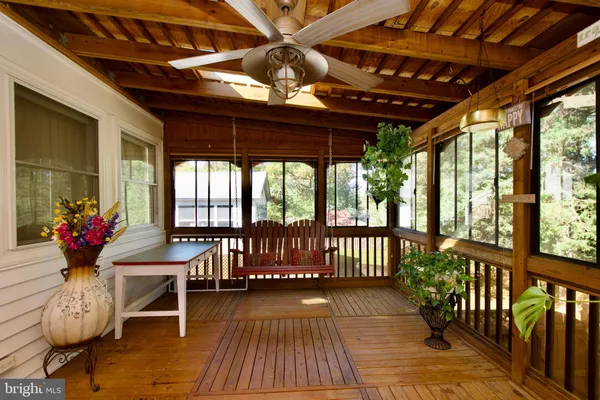 a view of a porch with furniture and wooden floor