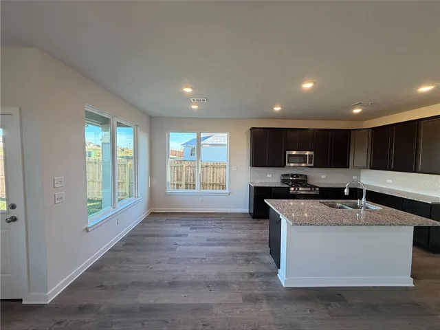 a kitchen with a sink and wooden floor