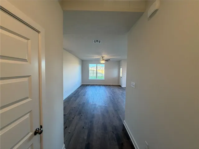 a view of empty room with window and wooden floor