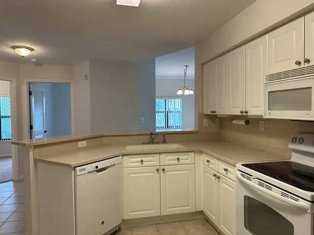 a kitchen with cabinets stainless steel appliances and sink