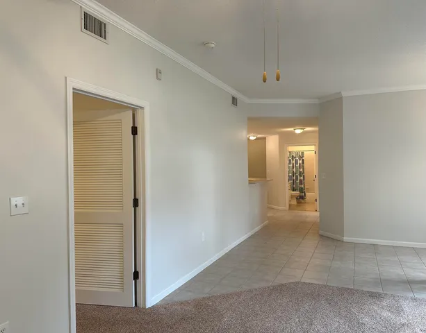 a view of a hallway to a kitchen with a sink and a fireplace