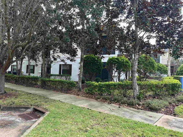 a front view of a house with a yard and potted plants