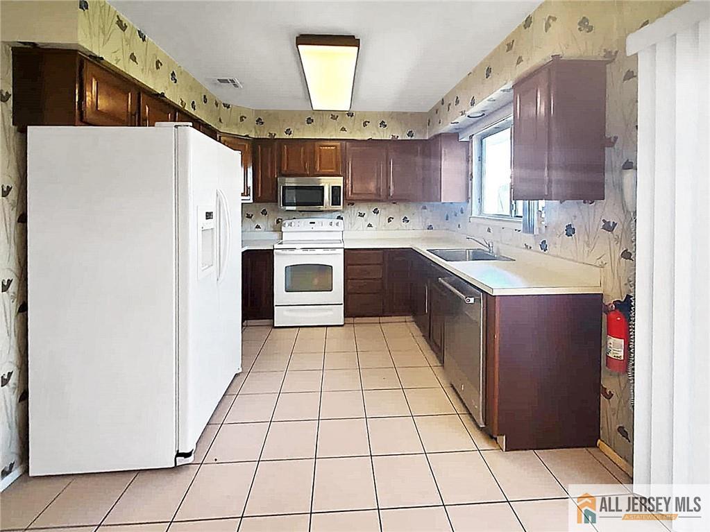742A Pompton Road, Unit A Monroe Township, NJ 08831 - Photo 6 of 23 a kitchen with a sink a refrigerator and cabinets