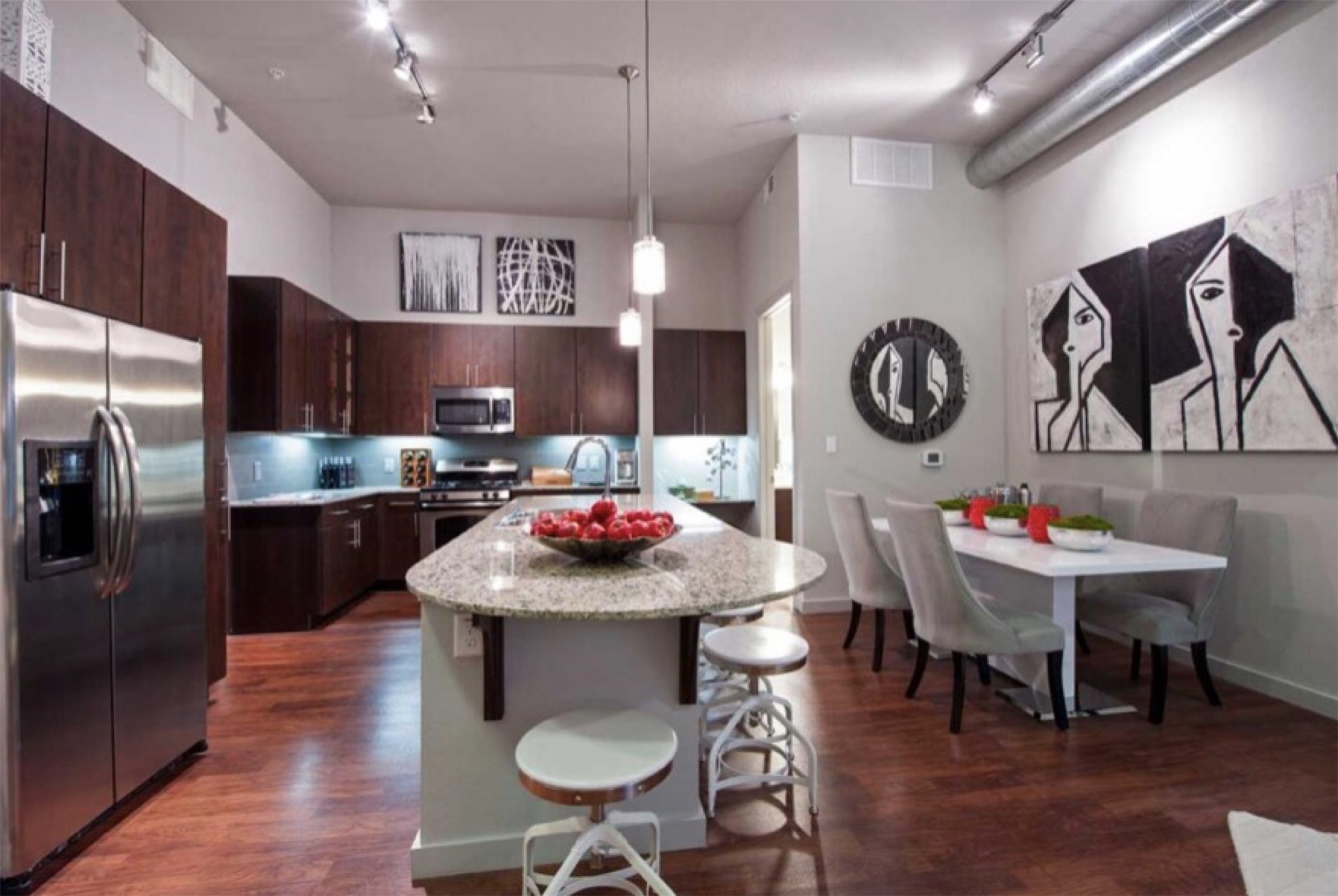 2525 McCue Road, Unit 125 Houston, TX 77056 - Photo 25 of 35 a kitchen with stainless steel appliances kitchen island granite countertop a dining table chairs and a refrigerator