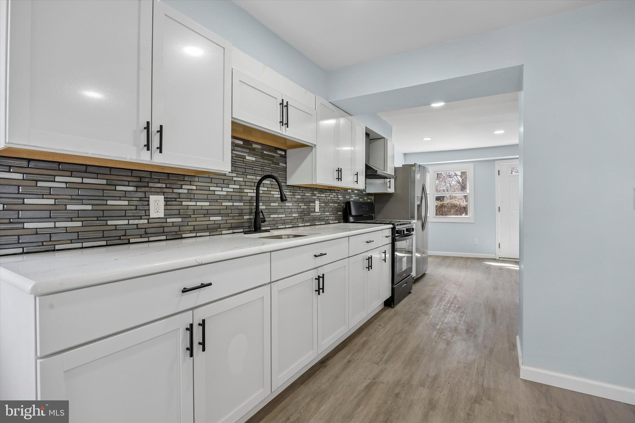 6 West Griffith Street Penns Grove, NJ 08069 - Photo 4 of 25 a kitchen with kitchen island granite countertop a sink cabinets and wooden floor