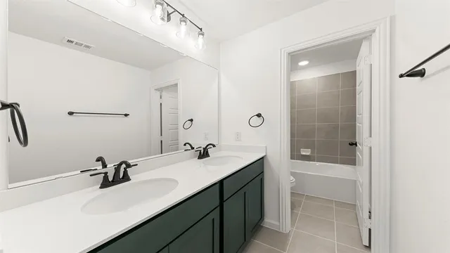 a bathroom with a sink vanity tub and shower