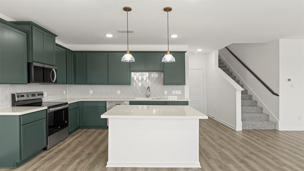 2524 YO Rnch Road Anna, TX 75409 - Photo 4 of 30 a kitchen with stainless steel appliances granite countertop a sink a stove and a wooden floors