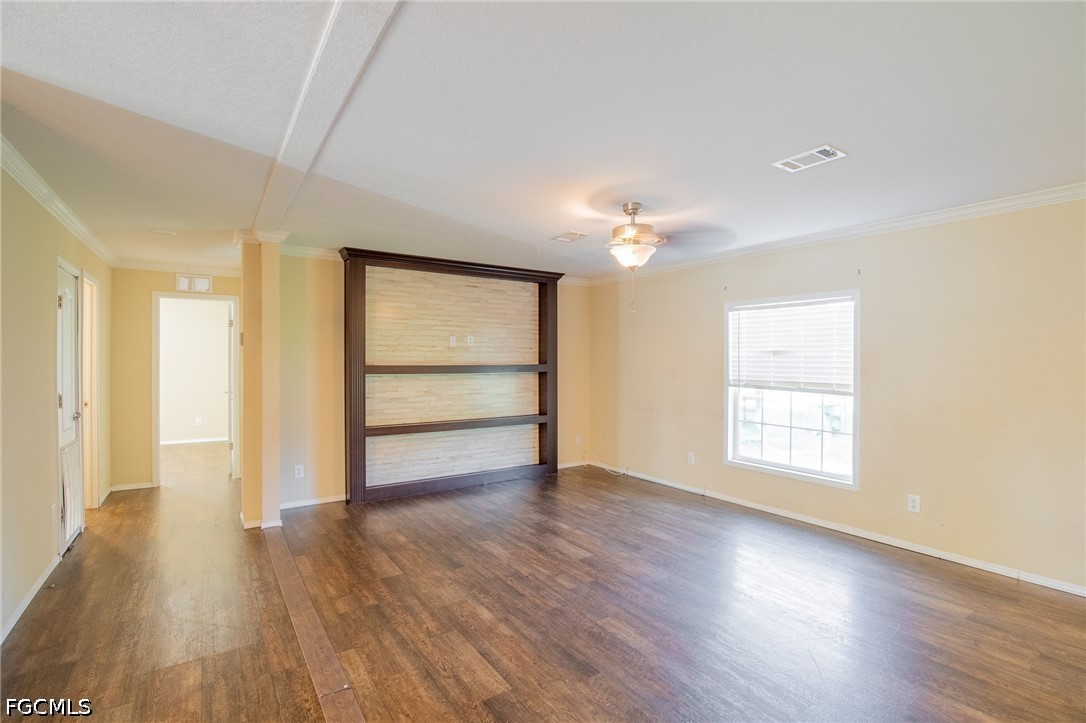 1580 Ridgdill Road Clewiston, FL 33440 - Photo 12 of 30 an empty room with wooden floor chandelier and windows