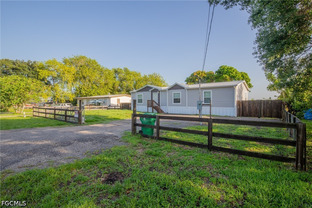 1580 Ridgdill Road Clewiston, FL 33440 - Photo 2 of 30 a view of a house with backyard and a tree