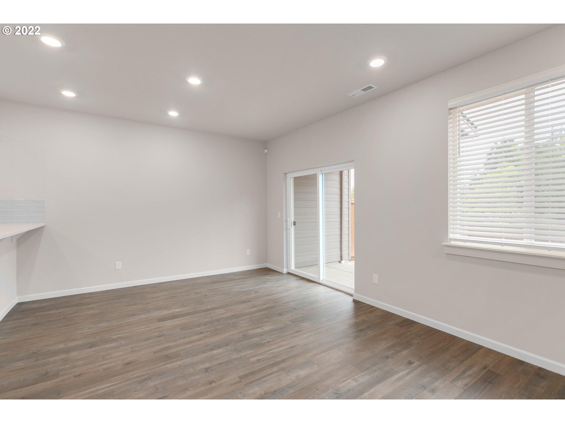 4225 South Cloverhill Way Ridgefield, WA 98642 - Photo 14 of 25 a view of an empty room with wooden floor and a window