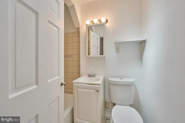 a bathroom with a toilet sink and mirror