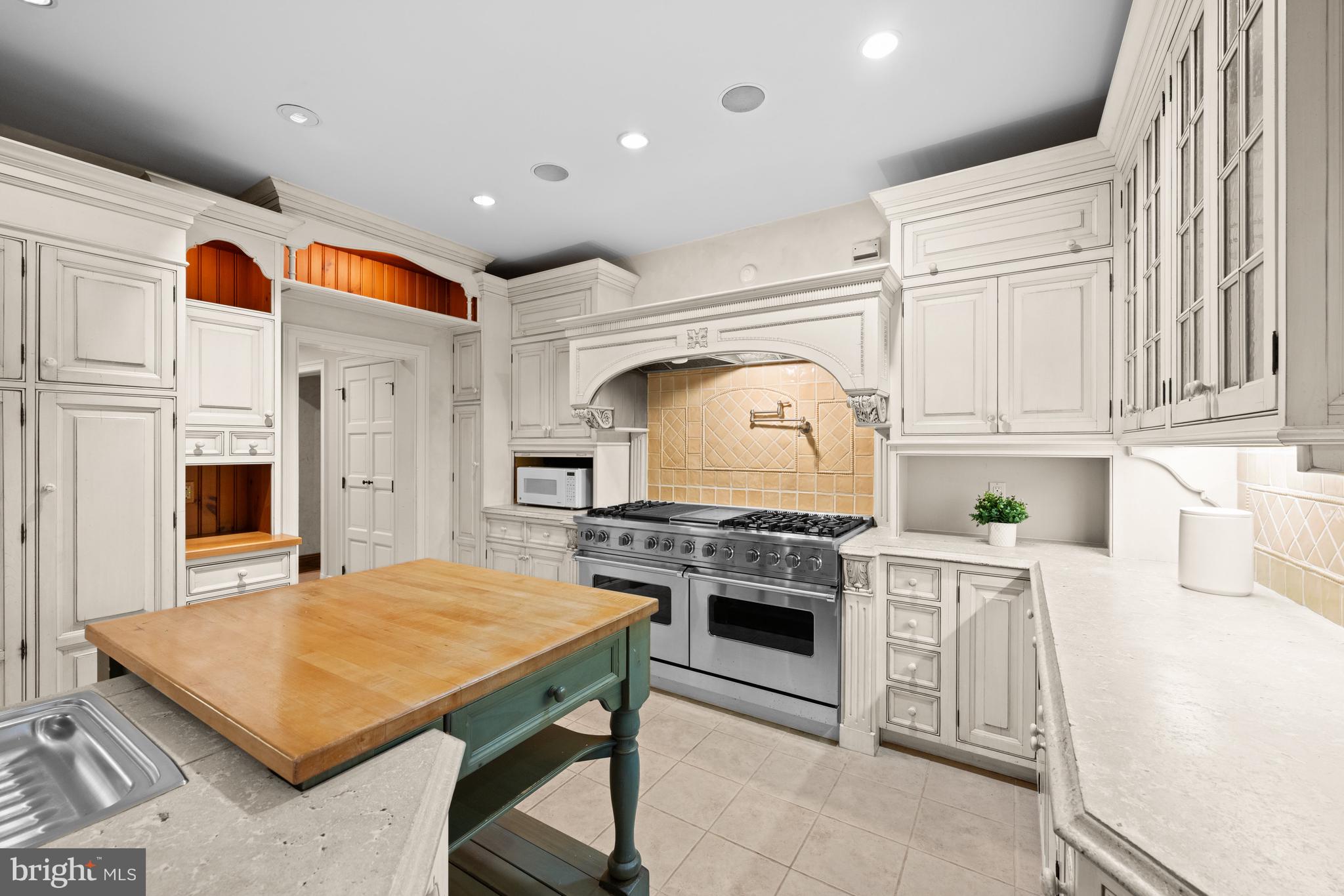 11552 Springridge Road Potomac, MD 20854 - Photo 14 of 65 a kitchen with stainless steel appliances granite countertop a stove top oven a sink dishwasher and white cabinets with wooden floor